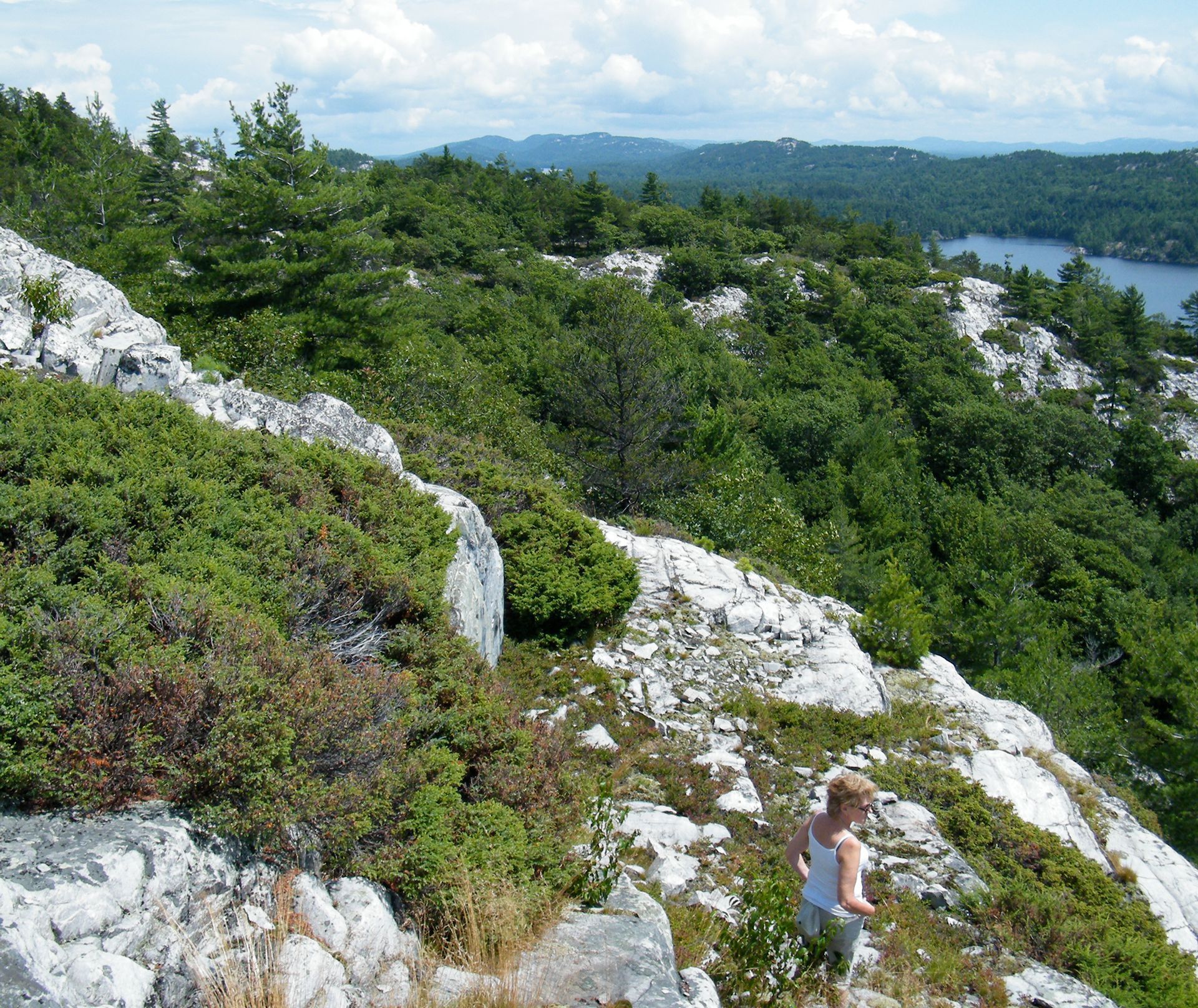 A woman hikes down a rocky cliff in Espanola.