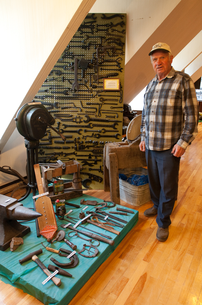 Victor Tremblay stands beside tool collection Mattawa_Museum